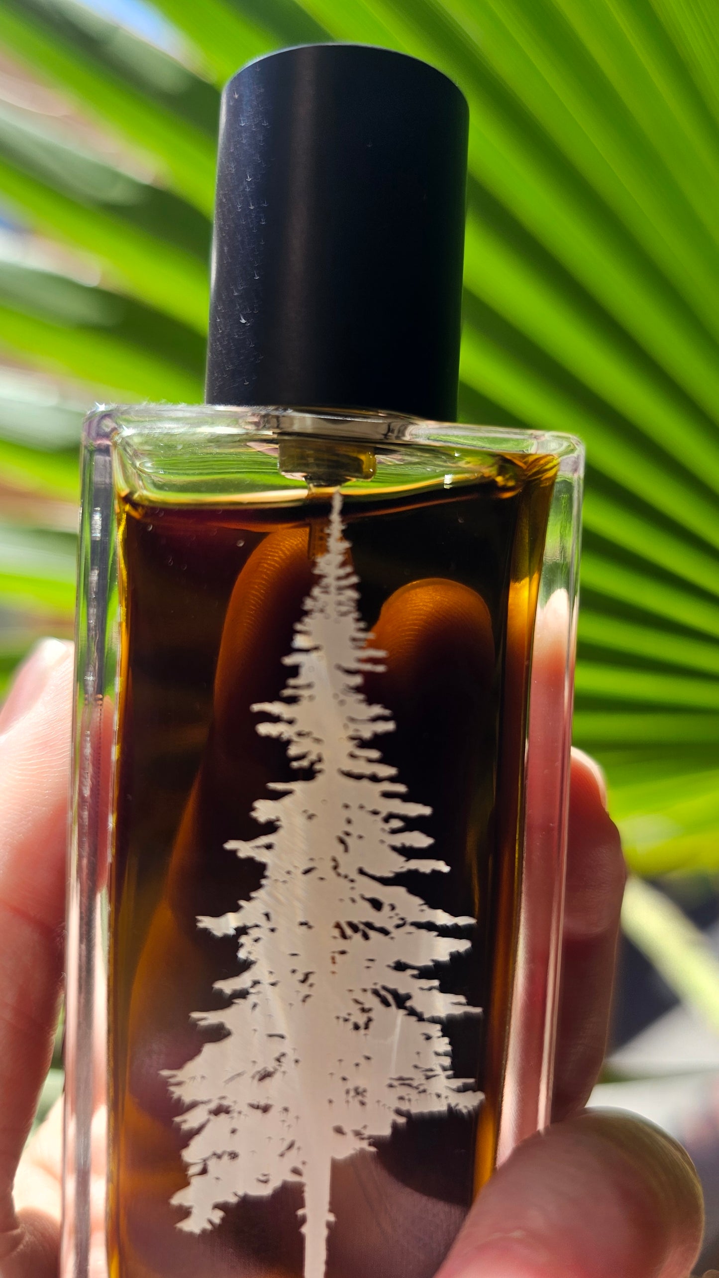 Apple -Tabac-Pinward -Perfume -lined -up -against- a -green -background